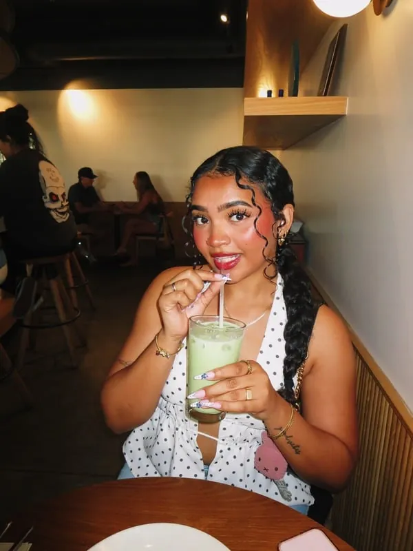 Kayla, the content creator behind Goose Socials, holding an iced drink